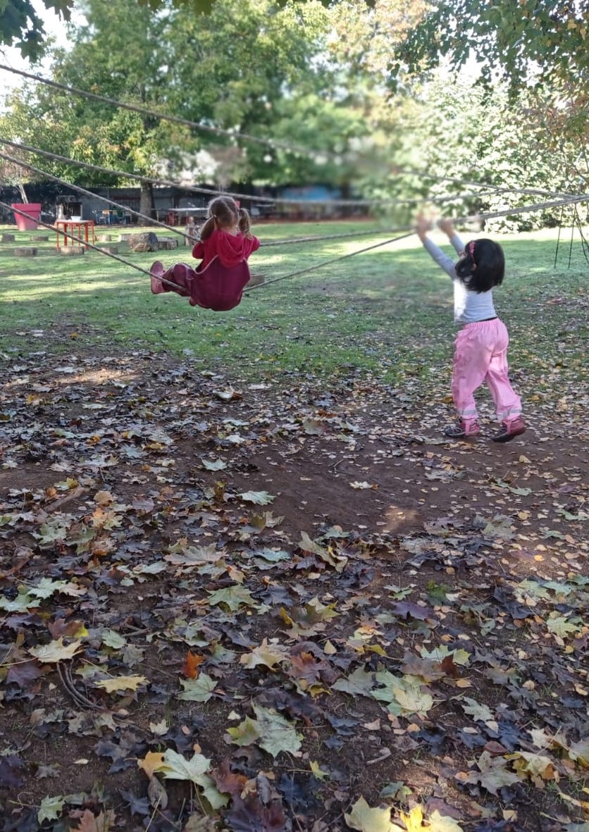 Bambine che giocano appese ad una corda.