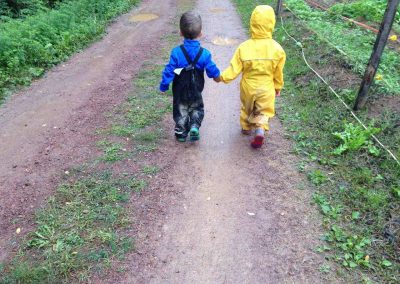 bambini con la tutina del bosco che camminano nella pioggia