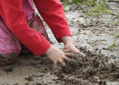 bambina che gioca con il fango